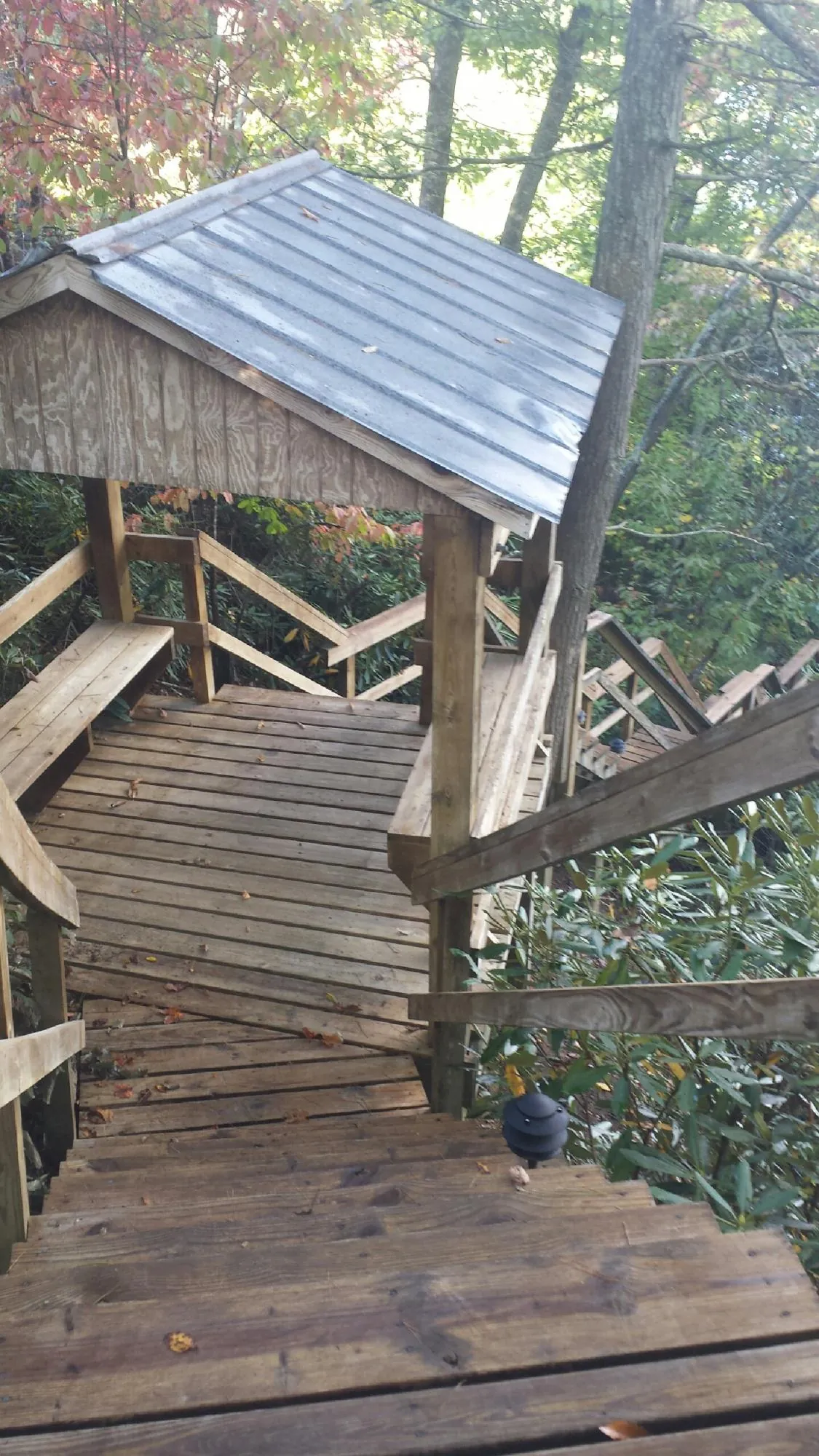 Metal roofed shelter over wooden steps on a wooded walkway — Skylight Repair & Installation work by our crew in West Mifflin