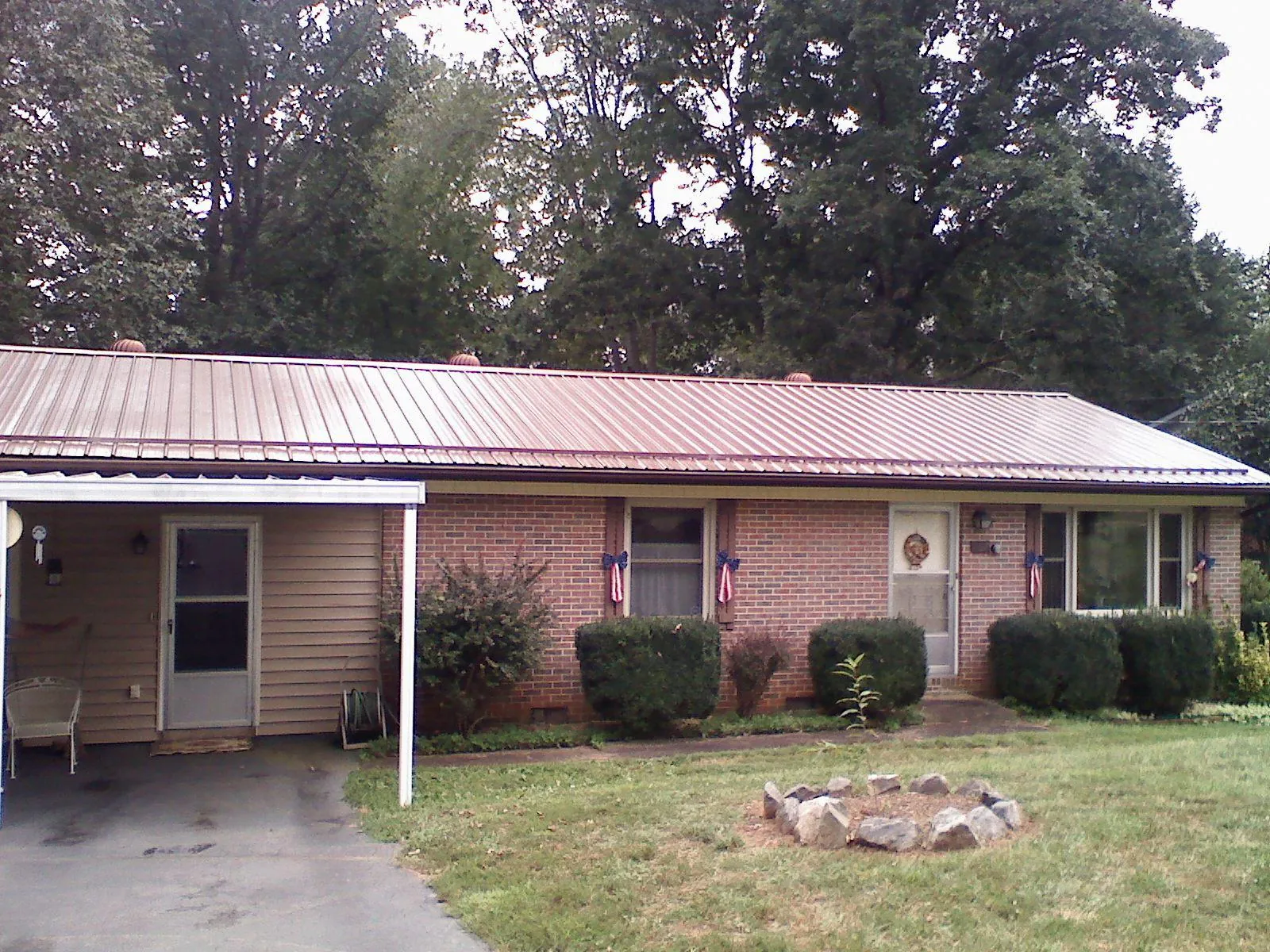 Bronze metal roof and carport on a brick ranch home — Roof Repair work by our crew in West Mifflin